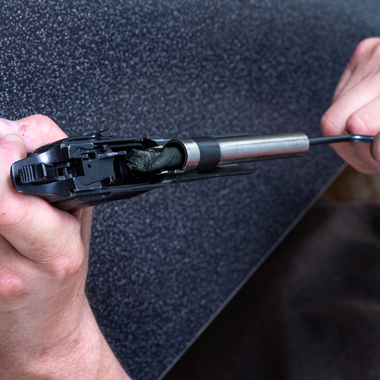 Person cleaning a gun barrel with a bore cleaner