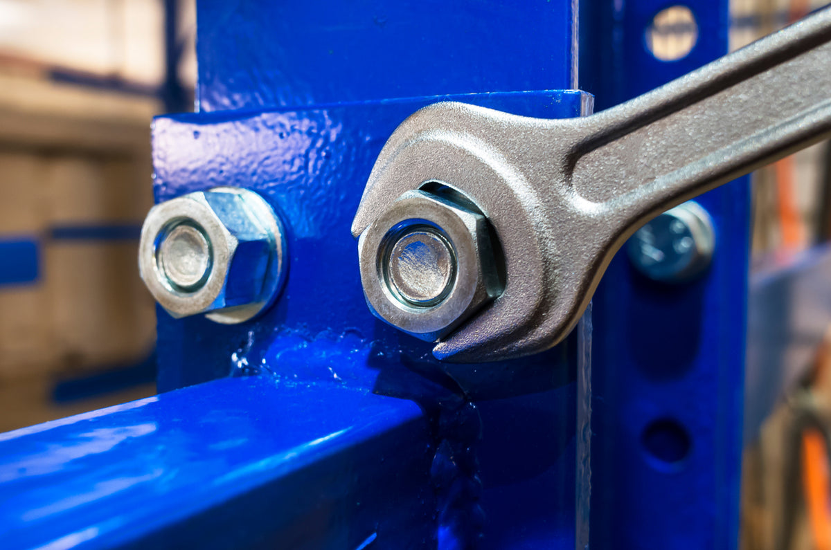 Close-up of a wrench on a blue mechanical component